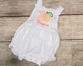 Mono de niña con apliques de números y estampado de melocotón para primer cumpleaños