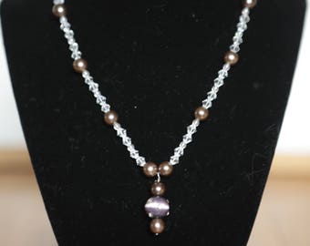 Collar artesanal con cuentas de cristal morado y dije de vidrio.