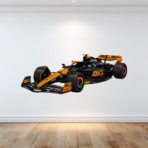 Peut inclure: Une voiture de course de Formule 1 arborant un design noir et orange avec des logos OKX et Chrome bien visibles. Le véhicule présente une silhouette aérodynamique profilée avec des pneus noirs dotés d'accents colorés sur les jantes.
