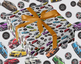 May include: A wrapped present with a gold ribbon, set against a backdrop of a pattern featuring colourful sports cars and wheels on a white surface. The cars are in various colours.