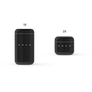 May include: Two black SMEG canisters. The taller canister is labelled "1X" and the shorter canister is labelled "2X". Both canisters have a rounded rectangular shape with a silver band around the top and the SMEG logo on the front.