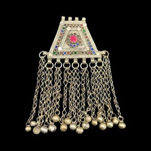 Puede incluir: Un colgante de plata con un diseño triangular y detalles de esmalte de colores. El colgante tiene una franja de cadenas con pequeñas bolas de plata en los extremos.