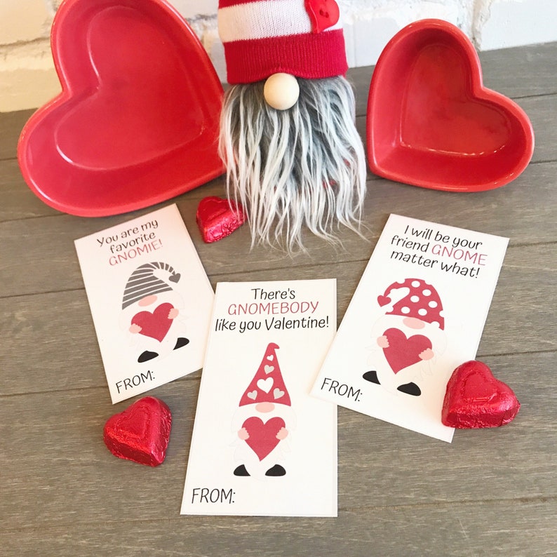 May include: Three Valentine's Day cards featuring gnomes holding hearts. The cards have different messages, including "You are my favorite GNOMIE!" and "There's GNOMEBODY like you Valentine!"