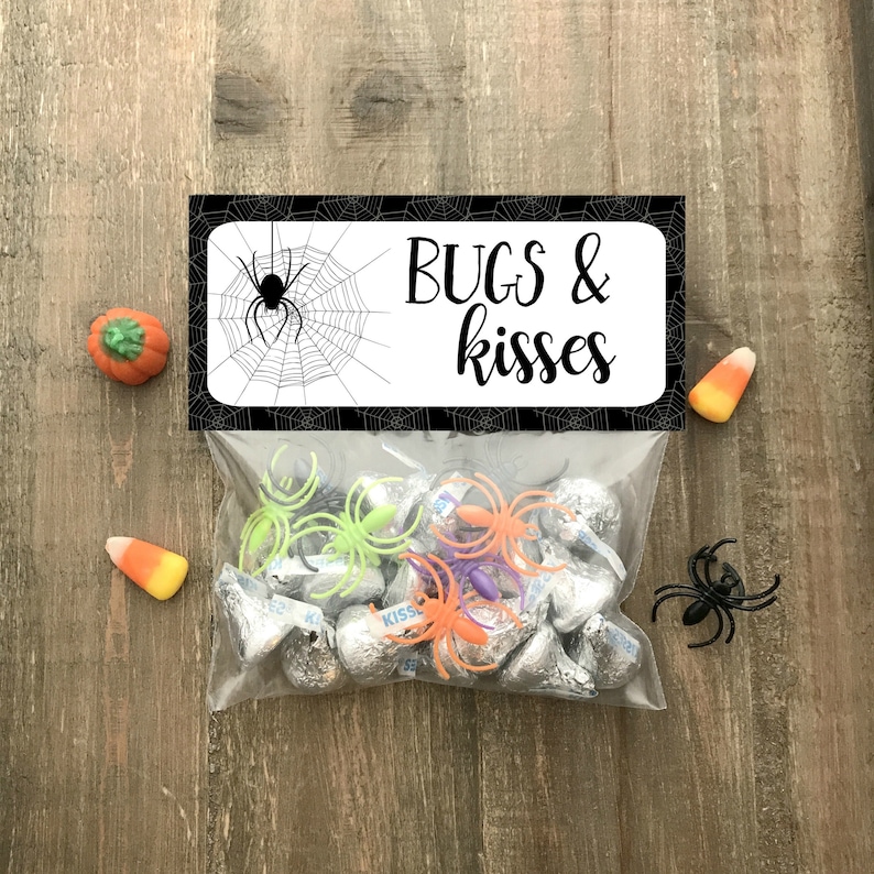 May include: A black and white printable Halloween treat bag label with a spider web and the text "BUGS & kisses". The bag is filled with chocolate kisses and small plastic spiders.