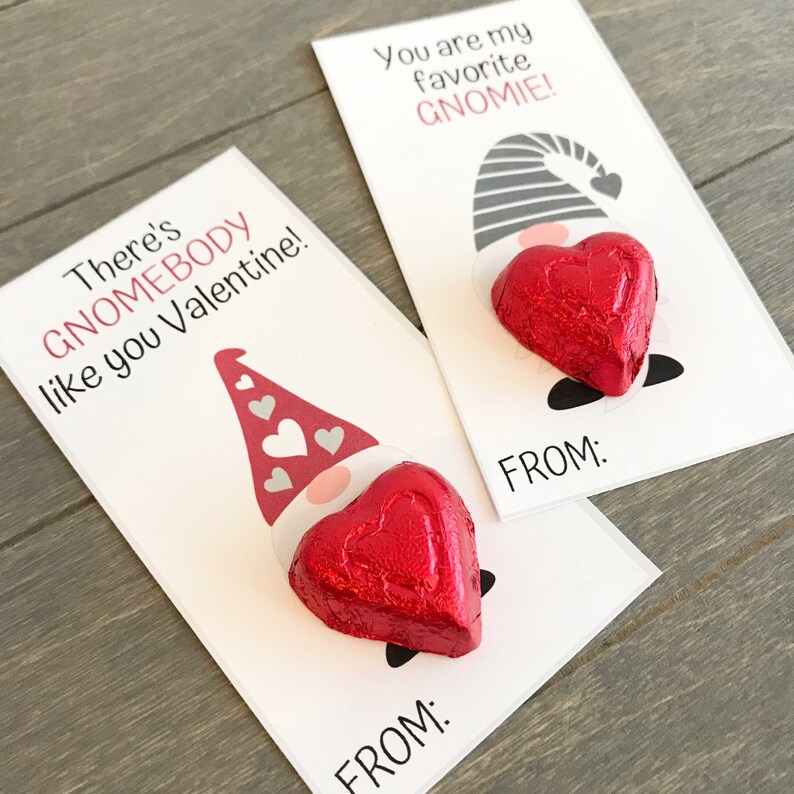 May include: Two Valentine's Day cards featuring a gnome with a heart-shaped chocolate. The first card says "There's GNOMEBODY like you Valentine!" and the second card says "You are my favorite GNOMIE!" Both cards have a space for "FROM:"