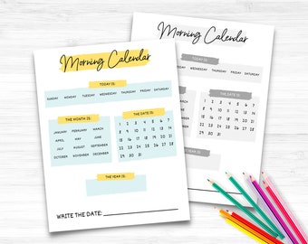 May include: Two white paper sheets with "Morning Calendar" text, featuring sections for the date, month, and year. One sheet has a calendar grid. Colored pencils in various colors are in the bottom right corner.