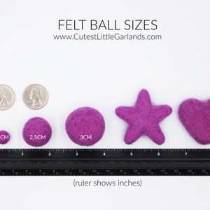 May include: A display of felt ball sizes, ranging from 1 cm to 3 cm, alongside star and heart shapes. The image includes a ruler showing inches and the text "FELT BALL SIZES" and "www.CutestLittleGarlands.com".