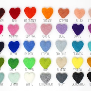 May include: A color chart featuring heart-shaped felt pieces in a variety of colors. The chart includes shades like maroon, red, orange, pink, purple, blue, green, yellow, and black, each labeled with its name. The felt hearts are arranged in rows and columns.