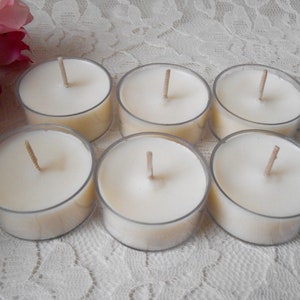 May include: Six unscented white tea light candles in clear plastic containers. The candles have wooden wicks.