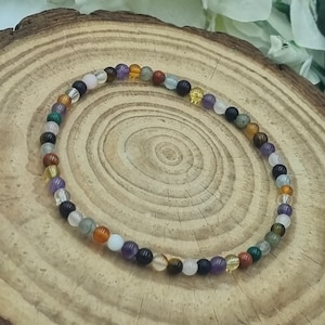 May include: A multi-colored beaded bracelet with various gemstones, including amethyst, tiger's eye, and clear quartz.