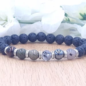 May include: A black lava rock bracelet with silver beads and various colored gemstone beads, including red tiger's eye, green aventurine, clear quartz, and grey hematite.