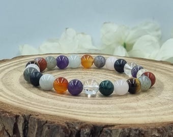 Puede incluir: Una pulsera elástica compuesta por cuentas esféricas lisas y multicolores. Las cuentas presentan una variedad de colores que incluyen naranja, morado, negro, blanco, verde y transparente, dispuestas en un patrón circular para la muñeca.