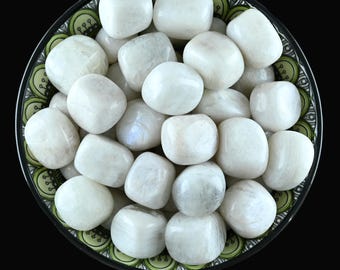 May include: A bowl filled with white moonstone tumbled stones. The stones are smooth and have a pearly sheen.