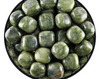 May include: A bowl filled with tumbled green jasper stones. The stones are smooth and polished, with a variety of shades of green.