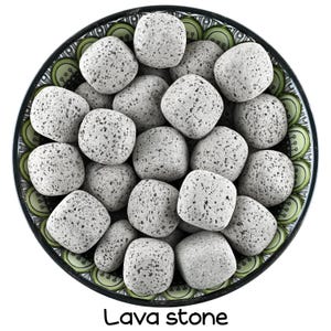 Puede incluir: Un bol lleno de piedras de lava grises. El bol tiene un diseño estampado verde y blanco. El texto "Lava stone" está escrito debajo del bol.