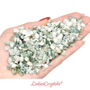 May include: A handful of green and white tumbled moss agate stones. The stones are small and irregular in shape.