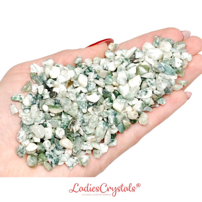 May include: A handful of green and white tumbled moss agate stones. The stones are small and irregular in shape.