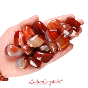 Ágata vermelha rolada, presente para amantes de cristais, pedra preciosa natural com faixas carmesim e propriedades curativas.