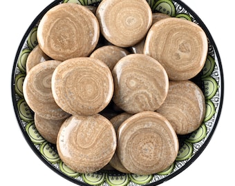 May include: A bowl filled with smooth, round, brown and white Eichenberg aragonite stones. The stones have a swirling pattern.