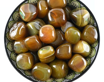 May include: A bowl filled with red-brown agate tumbled stones. The stones have a variety of brown, red, and white stripes and patterns.
