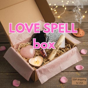 Könnte beinhalten: Eine rosa "Love Spell Box" mit einem herzförmigen Rosenquarz, einer brennenden herzförmigen Kerze, einem schwarzen Samtbeutel, einer Schriftrolle und einem kleinen Glasfläschchen mit Rosenblättern. Die Box ist mit rosa Seidenpapier ausgekleidet.