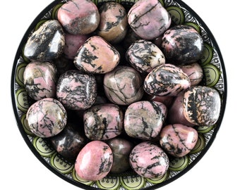 Può includere: Una ciotola di pietre di rodonite rosa e nera rotonde. Le pietre sono lisce e levigate, e hanno una varietà di forme e dimensioni.