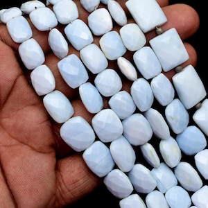 Peut inclure: Plusieurs rangées de perles de pierres précieuses bleu clair aux surfaces facettées. Les perles sont de formes variées, notamment rectangulaires et ovales, et sont enfilées ensemble. La couleur générale est un bleu pâle et doux, avec une légère translucidité.