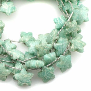 May include: A strand of light green star-shaped beads made of amazonite, strung on a silver wire.