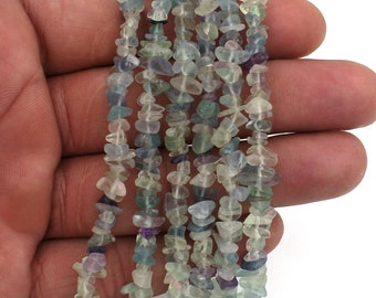 May include: A strand of light green, blue, and purple fluorite chip beads. The beads are irregular in shape and have a natural, tumbled finish.