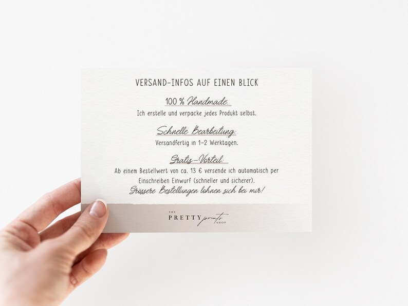 May include: A hand holding a cream-colored card with black text. The card reads "VERSAND-INFOS AUF EINEN BLICK" and details about handmade products, processing time, and shipping. The card has a light gray border and the logo "THE PRETTY PRINT" at the bottom.