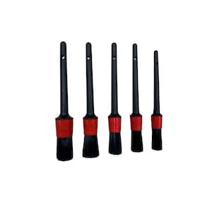 May include: Set of five black detailing brushes with red accents. The brushes have black bristles and are designed for cleaning and detailing.