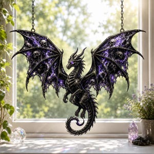 May include: A hanging dragon ornament featuring a black, textured body with glowing purple eyes. The expansive wings display a detailed pattern of skulls integrated into a swirling, dark purple and black nebula-like design, suspended by chains.