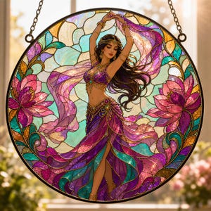 May include: Round stained glass window featuring a dancer in a purple and gold costume. The dancer is surrounded by lotus flowers and flowing fabric in shades of purple, pink, and teal. The window is framed with a black metal border and hanging chain.