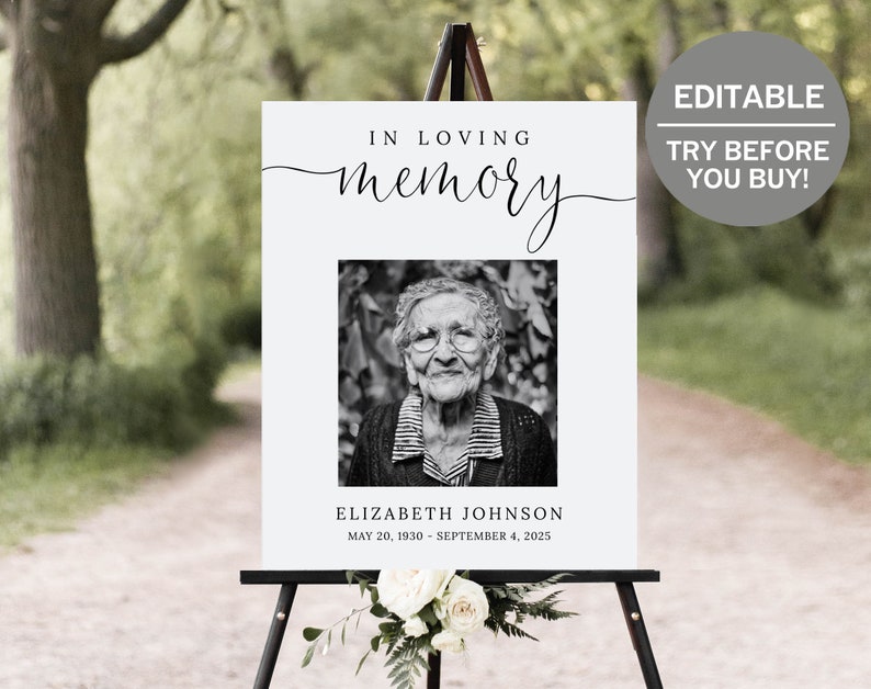 May include: A black and white photo memorial sign with the text "In loving memory" and a black and white photo of an older woman. The text below the photo reads "Elizabeth Johnson May 20, 1930 - September 4, 2025".