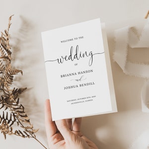 May include: A white wedding invitation with black calligraphy text. The text reads "Welcome to the wedding of Brianna Hanson and Joshua Bendil. Saturday, October 15th, 2030. Jacksonville, Florida."