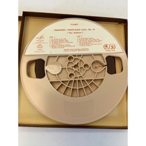 May include: A brown reel-to-reel tape cassette in a brown box. The cassette is labelled with the title "Prokofiev: Chout-Ballet Suite, Op. 21 (The Buffoon)". The cassette is labelled with the title "Prokofiev: Chout-Ballet Suite, Op. 21 (The Buffoon)".