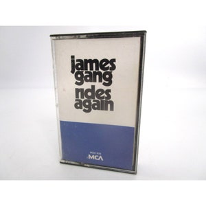 May include: A black cassette tape with a white label that reads "James Gang Rides Again" and a blue label with the text "MCA-1638 MCA".