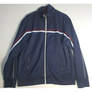 May include: A navy blue zip-up jacket with white and red stripes across the chest. The jacket has a white zipper and white piping around the edges.