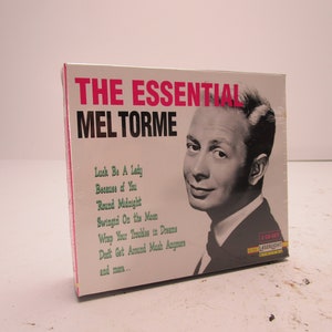Puede incluir: Una caja de CD blanca con un borde rosa. La parte delantera de la caja presenta una foto de Mel Torme, un cantante, y el texto "THE ESSENTIAL MEL TORME". El texto "Luck Be A Lady, Because of You, Round Midnight, Swingin On the Moon, Wrap Your Troubles in Dreams, Don't Get Around Much Anymore, and more..." está listado debajo de la foto. El texto "2 CD-SET" está en la esquina inferior derecha de la caja.