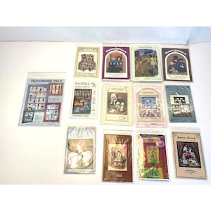May include: A collection of 12 vintage sewing patterns for dolls and quilts. The patterns feature a variety of designs, including patchwork pals, butterfly wings, and sweet annie.