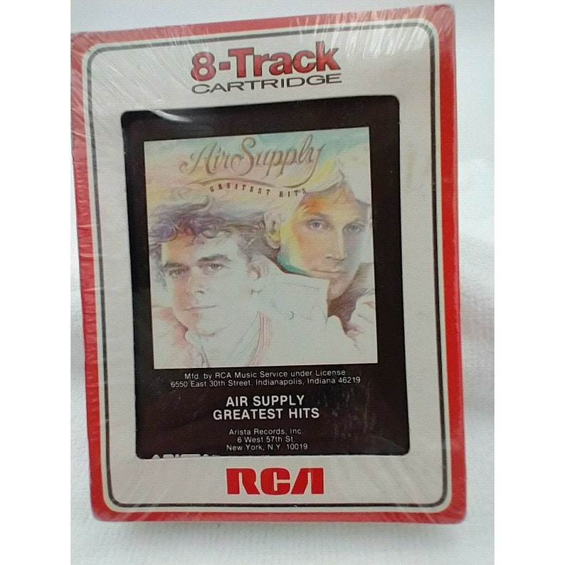 May include: An 8-track cartridge case with a red border. The front features a photo of the band Air Supply with the text "Air Supply Greatest Hits". The text "Mfd. by RCA Music Service under License 6550 East 30th Street, Indianapolis, Indiana 46219" is printed below the photo. The text "Air Supply Greatest Hits" is printed in a larger font below the license information. The text "Arista Records, Inc. 6 West 57th St. New York, NY 10019" is printed below the title. The RCA logo is printed in the bottom right corner.