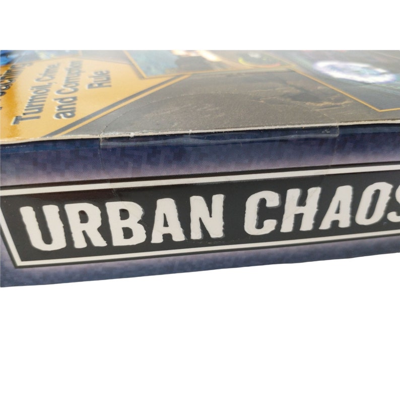 Pu&ograve; includere: Primo piano della scatola del gioco da tavolo "Urban Chaos". La scatola &egrave; blu con un bordo nero attorno al titolo. Il titolo &egrave; in lettere bianche.