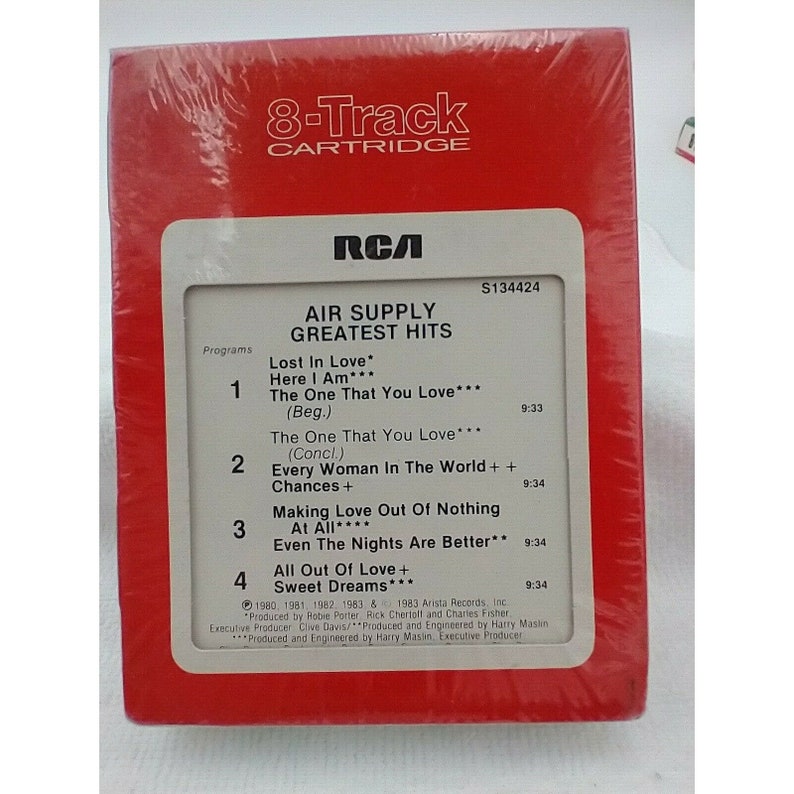 May include: A red 8-track cartridge case with a white label. The label features the RCA logo, the title "Air Supply Greatest Hits", and a list of songs with their corresponding track numbers and run times. The case is labeled with the product number S134424.