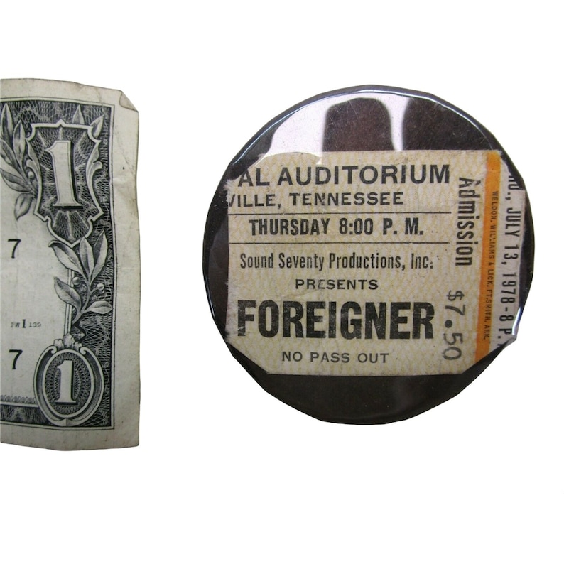 Peut inclure: Un bouton noir et blanc avec une &eacute;tiquette blanche qui indique "AL AUDITORIUM, VILLE, TENNESSEE, JEUDI 8:00 P.M., Sound Seventy Productions, Inc. PRESENTE FOREIGNER, NO PASS OUT, Admission 7,50 $, WEDLON, WILLIAMS & LICK, FTARITH, ARE, O., JUILLET 13, 1978-8 P."