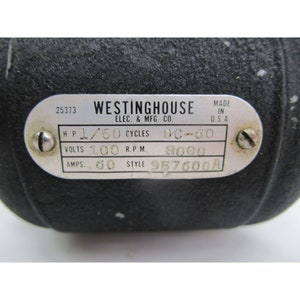 May include: A black metal Westinghouse electric motor with a label that reads "25373 WESTINGHOUSE ELEC. & MFG. CO. MADE IN U.S.A. H.P. 1/50 CYCLES DC-60 VOLTS 100 R.P.M. 9000 AMPS. 60 STYLE 957600A"