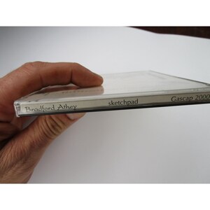 May include: Close-up of a CD case with the text "Bradford Athey" and "sketchpad" on the spine. The text "Gascap 2000" is on the right side of the case.