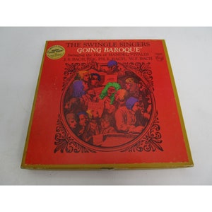 K&ouml;nnte beinhalten: Ein rotes Vinyl-Schallplattencover mit goldfarbenem Rand. Das Cover zeigt eine farbenfrohe Illustration einer Gruppe singender Menschen. Der Albumtitel lautet "The Swingle Singers Going Baroque" und der Text "Swinging the Hits of Handel, Vivaldi, J.S. Bach, K. Ph. E. Bach, W.F. Bach" ist unter dem Titel gedruckt.