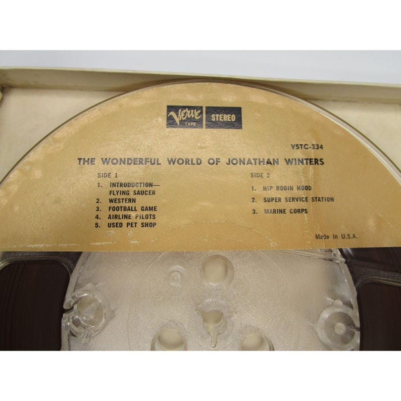 May include: A vintage reel-to-reel audio tape with a brown label. The label reads "The Wonderful World of Jonathan Winters" and lists the songs on each side of the tape. The tape is labeled "Verve Tape Stereo" and "VSTC-234".