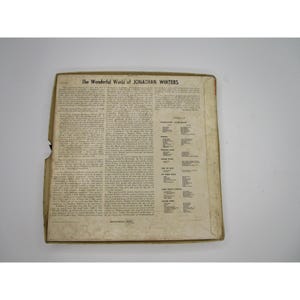 May include: The back of a record album cover for "The Wonderful World of Jonathan Winters". The cover is beige with black text. The text includes the album title, the artist's name, and a list of songs on the album.