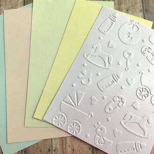 Itens de bebê com fundo em relevo em papel cartão brilhante, enfeite de cartão, scrapbooking de boas-vindas a um novo bebê, diário de lixo, anúncios de bebê, convites